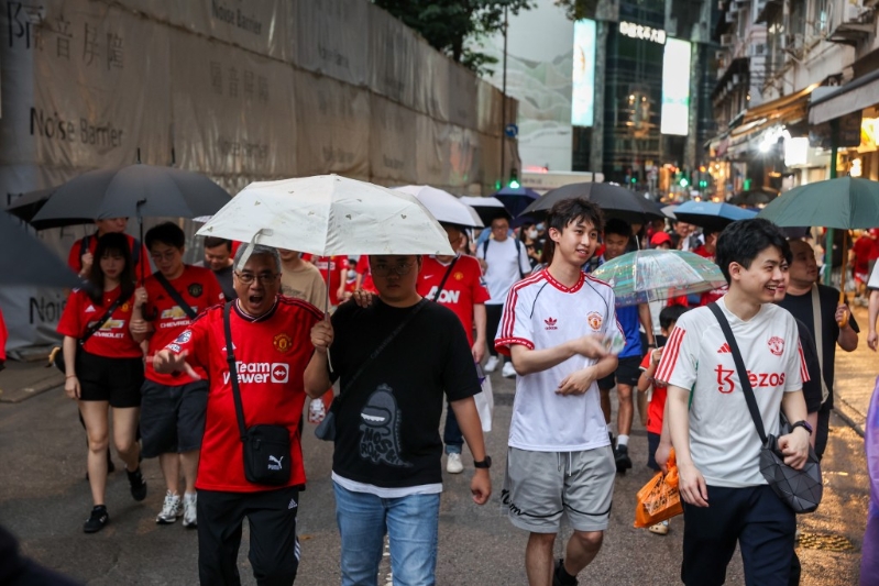 球迷冒雨入场。 何家豪摄 球迷冒雨入场。 何家豪摄