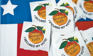 去年乔治亚州一个投票站内的桌子放着贴纸。 去年乔治亚州一个投票站内的桌子放着贴纸。