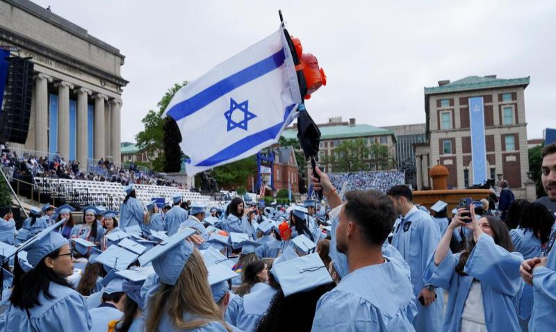 今年5月21日,美国纽约市曼哈顿哥伦比亚大学主校区毕业典礼上,一名学生手持以色列国旗。路透社.jpg 今年5月21日,美国纽约市曼哈顿哥伦比亚大学主校区毕业典礼上,一名学生手持以色列国旗。路透社.jpg