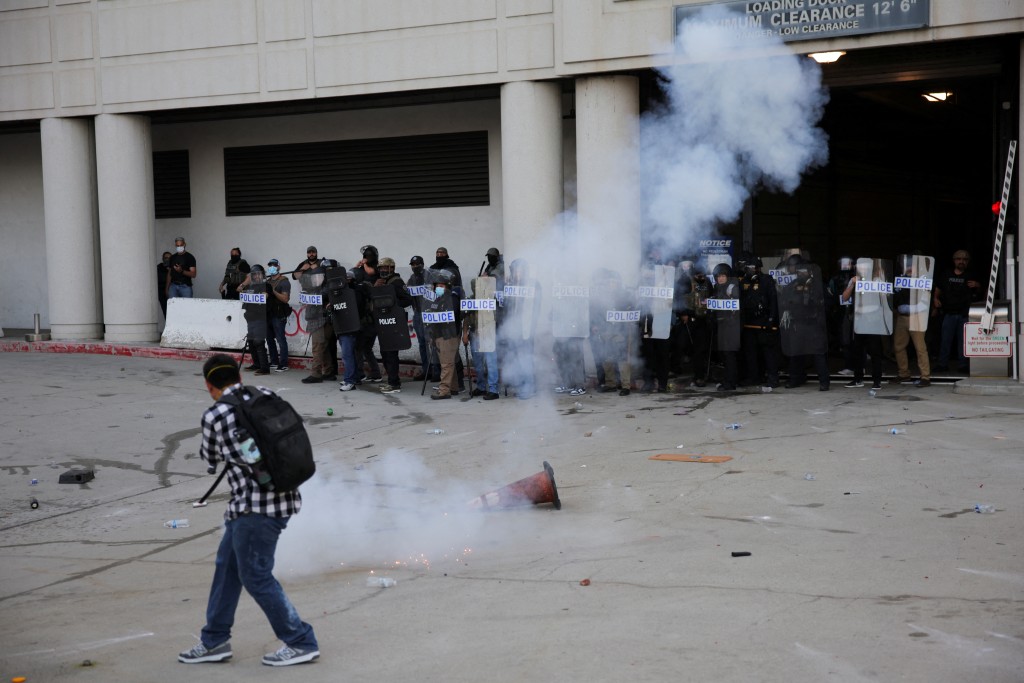 执法人员发射闪光弹,试图驱散示威者。 执法人员发射闪光弹,试图驱散示威者。