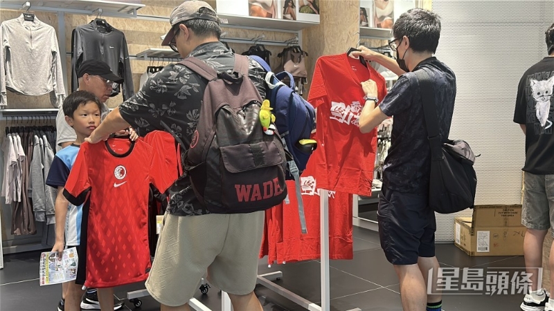 有家长为小朋友选购球衣。 刘汉权摄 有家长为小朋友选购球衣。 刘汉权摄