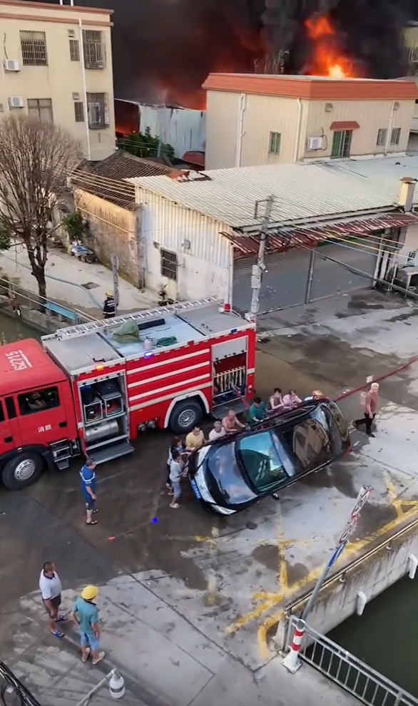 众人合力将堵路的私家车推翻。 众人合力将堵路的私家车推翻。