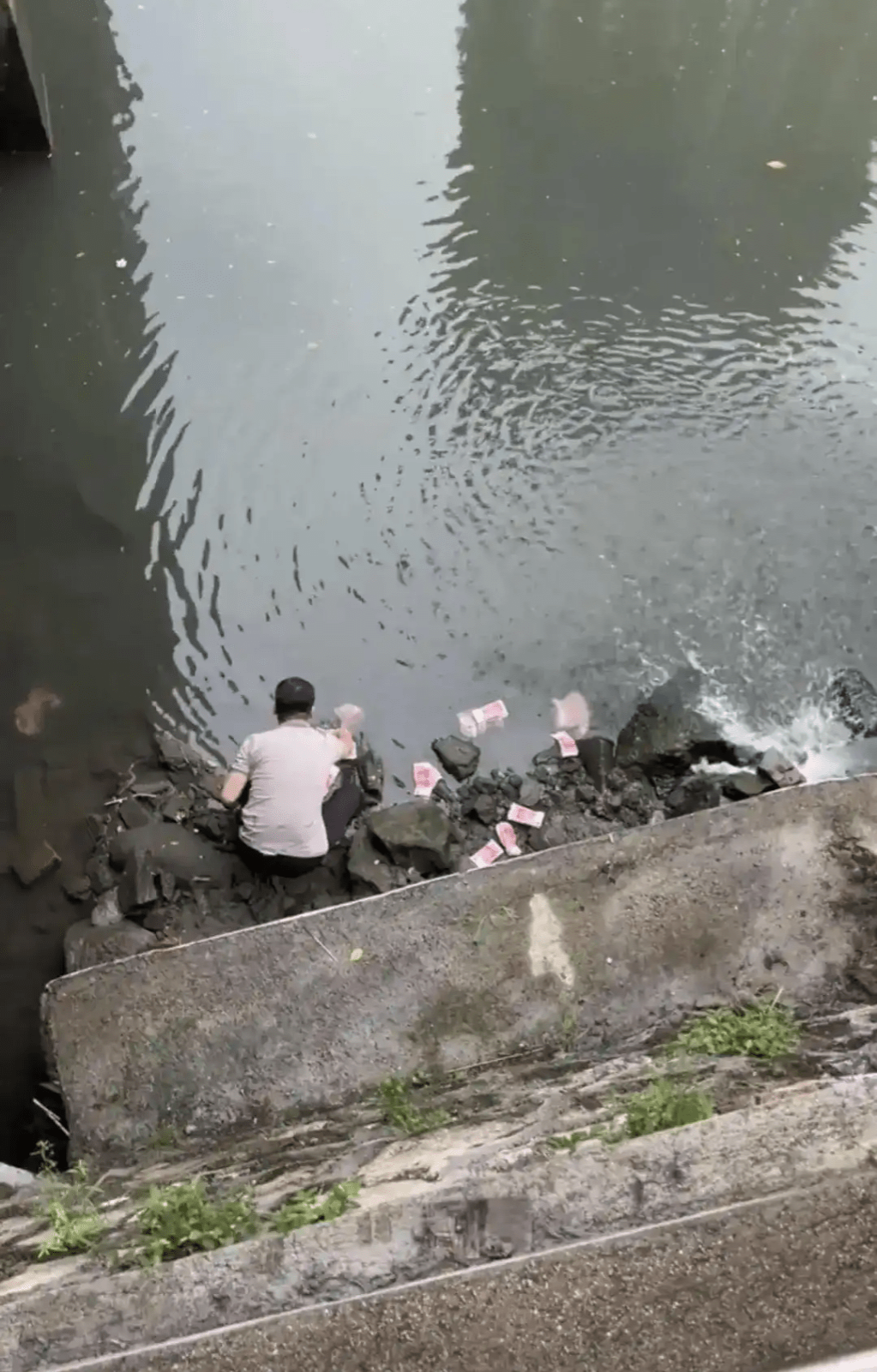 男子河道捡走河道中的现金。 男子河道捡走河道中的现金。