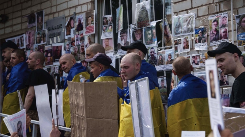 获释回家的乌克兰士兵仔细观看失踪人士兵照片及家属留言。 美联社.jpeg 获释回家的乌克兰士兵仔细观看失踪人士兵照片及家属留言。 美联社.jpeg