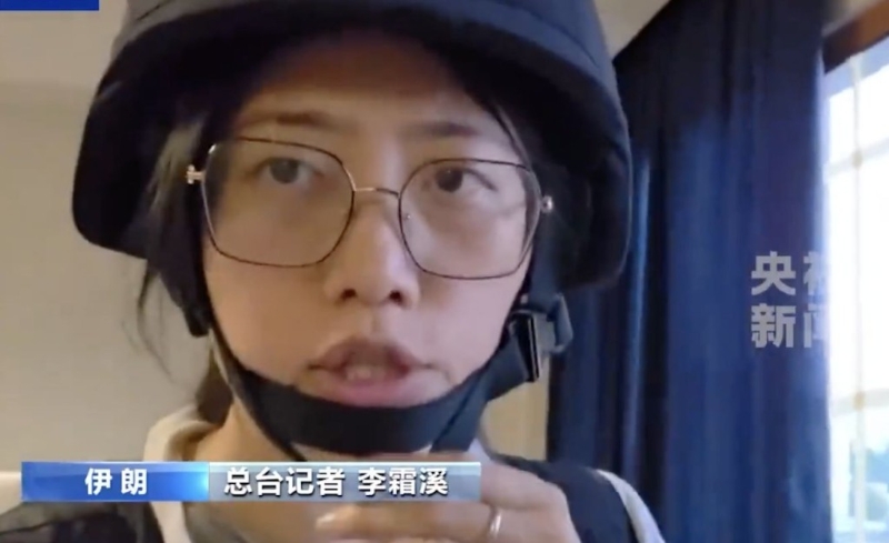央视记者李霜溪全副武装进行报道。 央视截图 央视记者李霜溪全副武装进行报道。 央视截图
