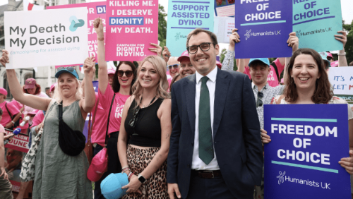 2025年6月20日,英国下议院投票通过辅助死亡合法化法案后,英国议员汤姆·戈登与举着标语牌的人们合照。 2025年6月20日,英国下议院投票通过辅助死亡合法化法案后,英国议员汤姆·戈登与举着标语牌的人们合照。