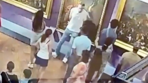 一名身穿白衣上衣男子自拍时绊倒,不慎撞破一幅18世纪名画。 一名身穿白衣上衣男子自拍时绊倒,不慎撞破一幅18世纪名画。