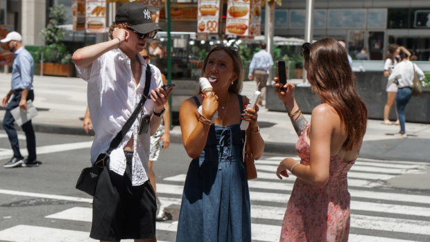 约纽受热浪影响下,民众吃雪糕消暑。美联社 约纽受热浪影响下,民众吃雪糕消暑。美联社
