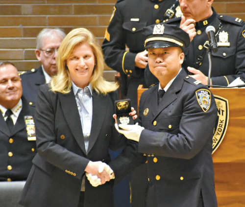 曾昌武(右)从蒂施手中接过新警徽。 曾昌武(右)从蒂施手中接过新警徽。