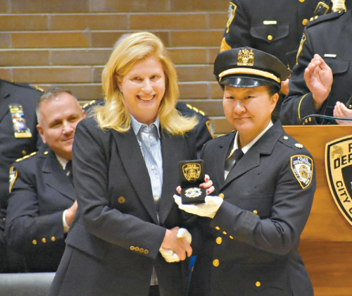 潘苏利文(右)从蒂施手中接过新警徽。 潘苏利文(右)从蒂施手中接过新警徽。