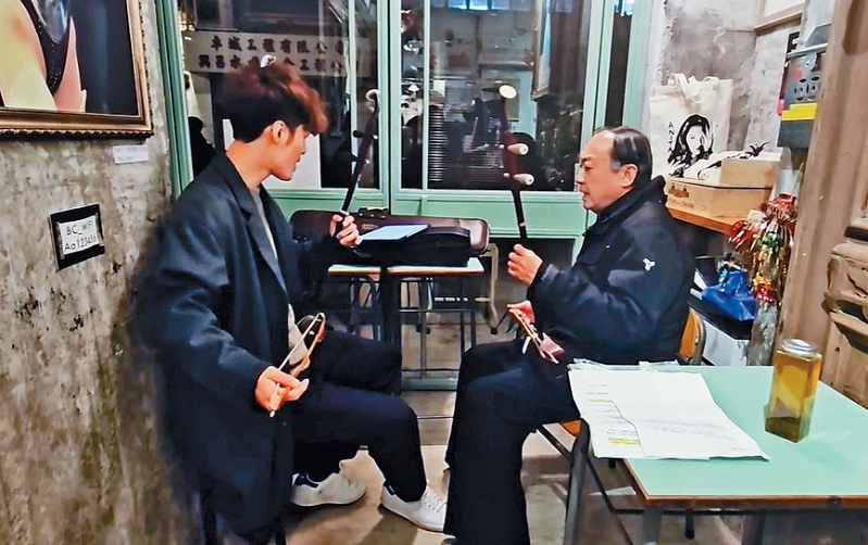 朱芸编教许冠文拉二胡,边唱边奏南音《游十殿》。 朱芸编教许冠文拉二胡,边唱边奏南音《游十殿》。