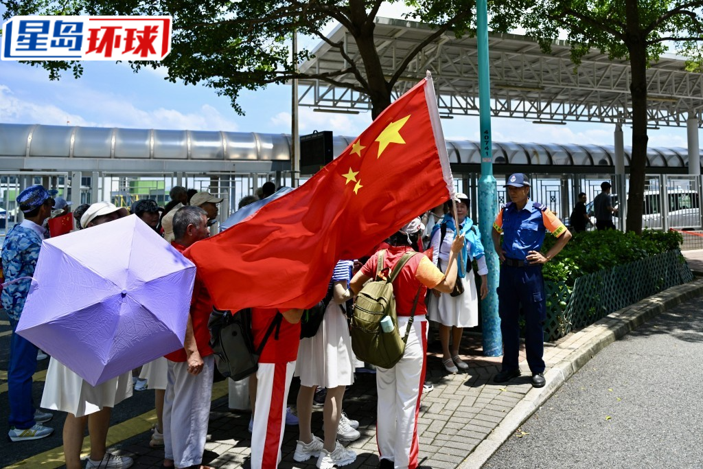 有市民手持国旗到来。 有市民手持国旗到来。