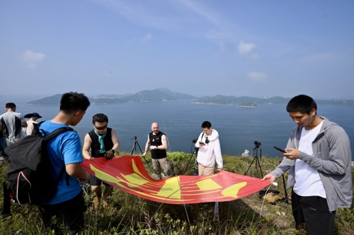 有市民于玉桂山顶上举起自制的“军强民乐”旗帜,表示是回应山东舰进港时甲板上的“国安家好”字句。 有市民于玉桂山顶上举起自制的“军强民乐”旗帜,表示是回应山东舰进港时甲板上的“国安家好”字句。