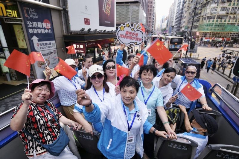 巴士巡游期间,车上嘉宾不断向路人挥舞国旗,高喊“庆香港回归 贺国安立法”口号。 巴士巡游期间,车上嘉宾不断向路人挥舞国旗,高喊“庆香港回归 贺国安立法”口号。