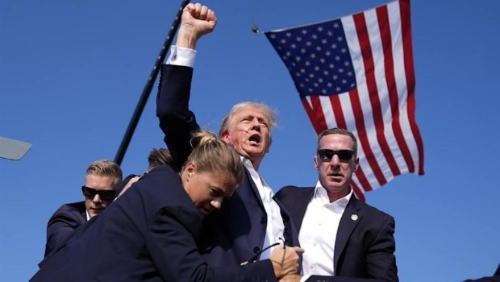 特朗普去年在宾州造势遇刺,右耳受伤流血,但他展现不屈,举拳高喊战斗。 特朗普去年在宾州造势遇刺,右耳受伤流血,但他展现不屈,举拳高喊战斗。