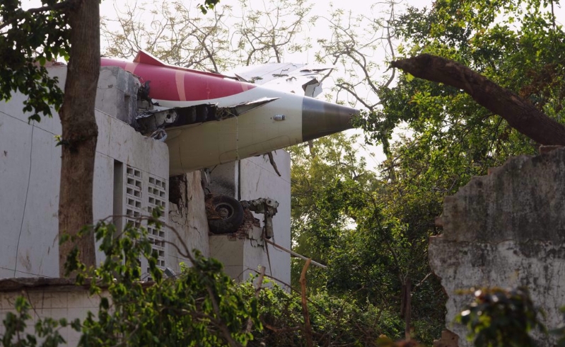 印航波音787客机12日起飞不久就坠毁,机尾卡在当地社区一处学校的宿舍顶楼。 印航波音787客机12日起飞不久就坠毁,机尾卡在当地社区一处学校的宿舍顶楼。