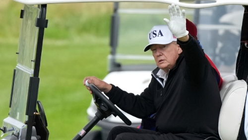 美国总统特朗普27日在苏格兰登拜里(Turnberry)开高球车,向在场媒体记者挥手致意。美联社 美国总统特朗普27日在苏格兰登拜里(Turnberry)开高球车,向在场媒体记者挥手致意。美联社