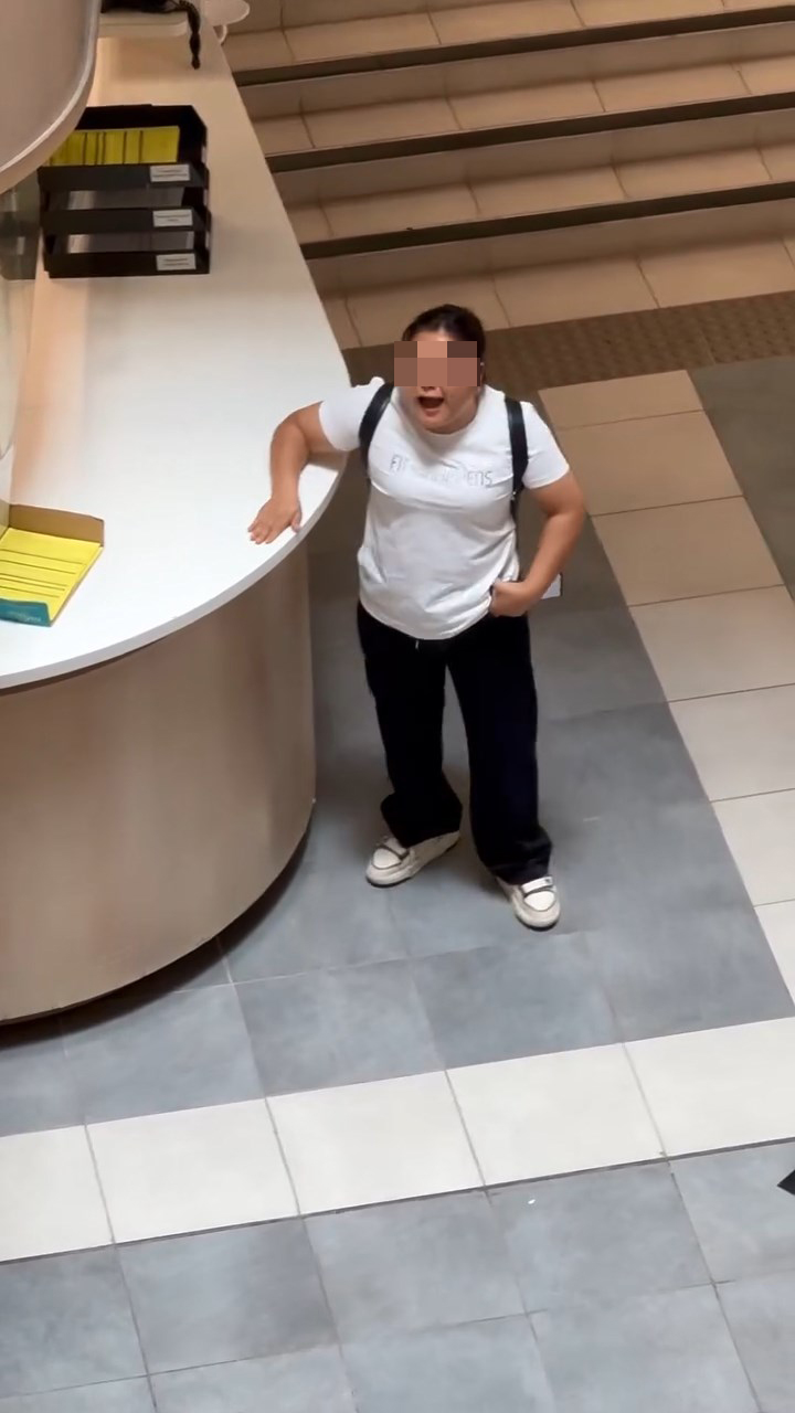 女子不断拿起柜枱的单张不停拍打枱面及玻璃。k 女子不断拿起柜枱的单张不停拍打枱面及玻璃。k