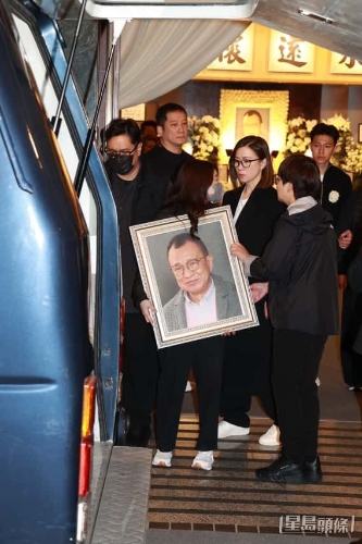 许惠菁捧着遗照上灵车随行。 许惠菁捧着遗照上灵车随行。