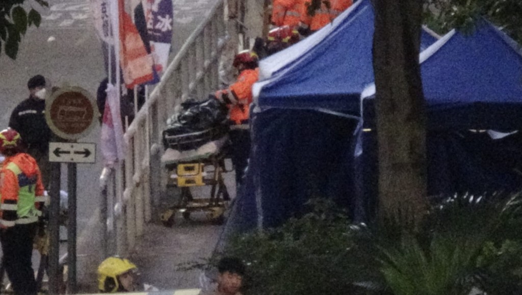 仵工清晨从受灾单位抬出五具遗体,其中两具体形明显较小。 仵工清晨从受灾单位抬出五具遗体,其中两具体形明显较小。