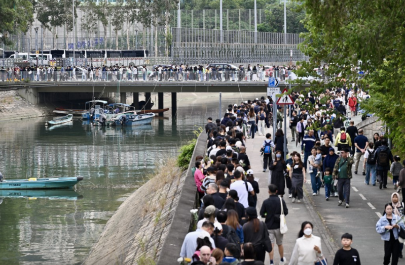 排队献花的人龙延伸至大埔河行人径。 排队献花的人龙延伸至大埔河行人径。