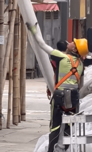 在柴湾长汇工业大厦外,今日仍有工人在拆除棚网时一边食烟一边拆网 在柴湾长汇工业大厦外,今日仍有工人在拆除棚网时一边食烟一边拆网