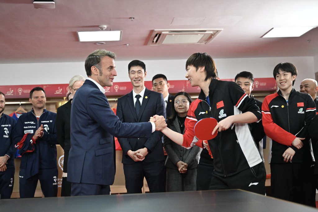 马克龙与中国队球员王曼昱握手。 马克龙与中国队球员王曼昱握手。