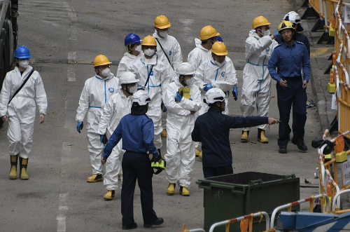 一众人士身穿全套白色保护衣。 一众人士身穿全套白色保护衣。