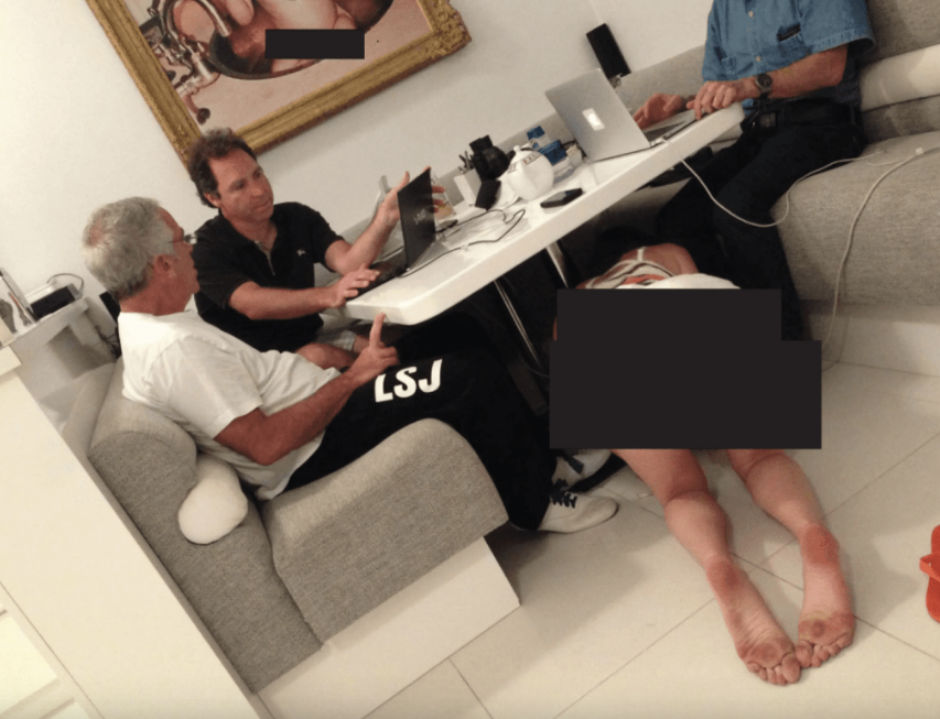 画面显示,爱泼斯坦与另外两名男子安坐桌前操作手提电脑,神情若无其事,而桌下则有一名身穿比基尼的女子伏地爬行,墙上更挂有一幅赤裸婴儿图像。 画面显示,爱泼斯坦与另外两名男子安坐桌前操作手提电脑,神情若无其事,而桌下则有一名身穿比基尼的女子伏地爬行,墙上更挂有一幅赤裸婴儿图像。