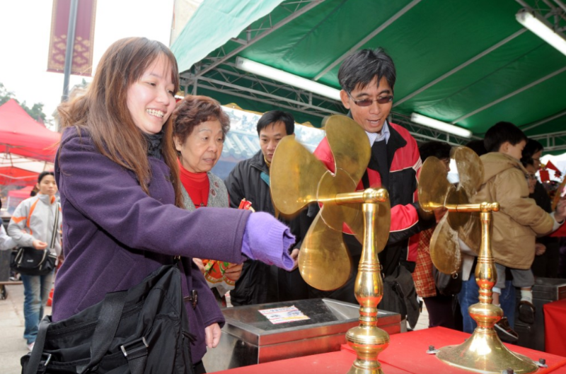 善信转动风车、祈求来年好运。 善信转动风车、祈求来年好运。