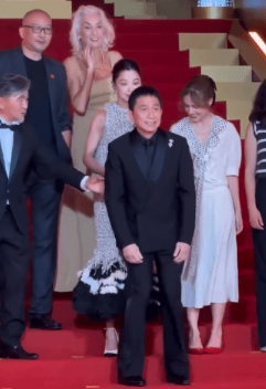 梁朝伟大合照时连环企错位。 梁朝伟大合照时连环企错位。
